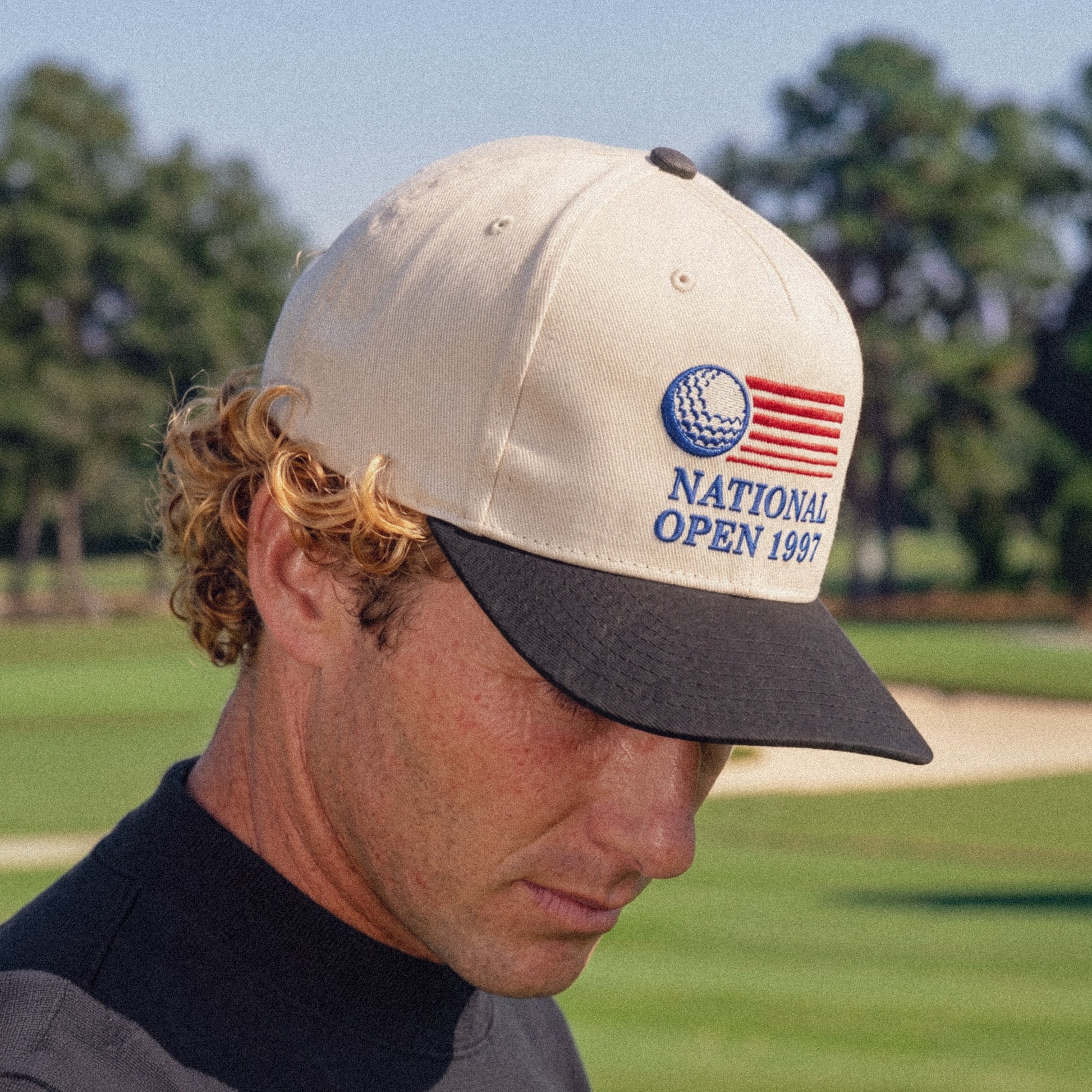 Golfer wearing the National Open 1997 cap on the course